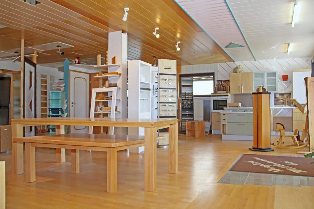 Ausstellungsraum der Schreinerei Lutz mit verschiedenen Möbeln und Holzoberflächen