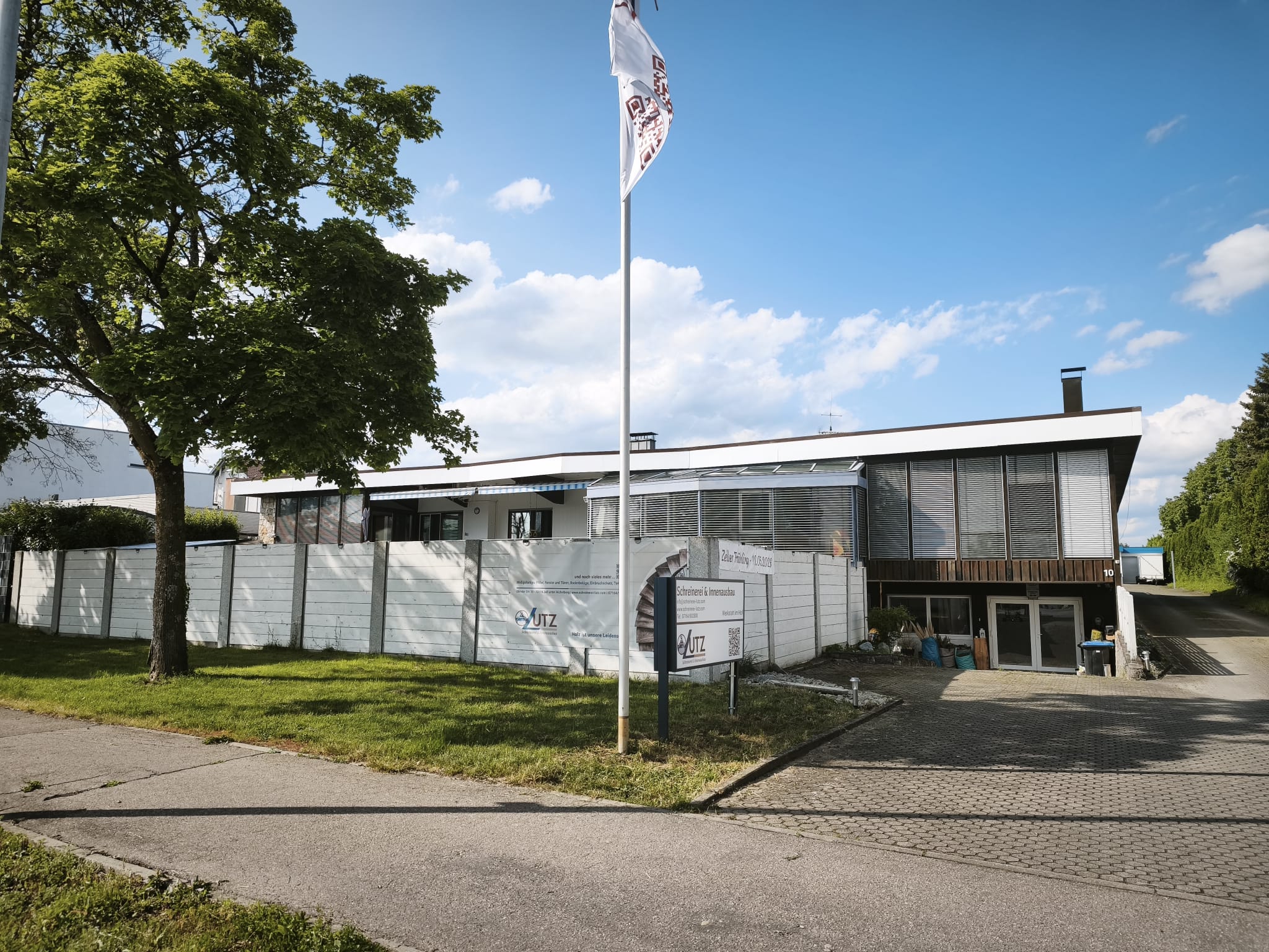 Betriebsgebäude der Schreinerei Lutz mit Firmenfahne in Zell unter Aichelberg