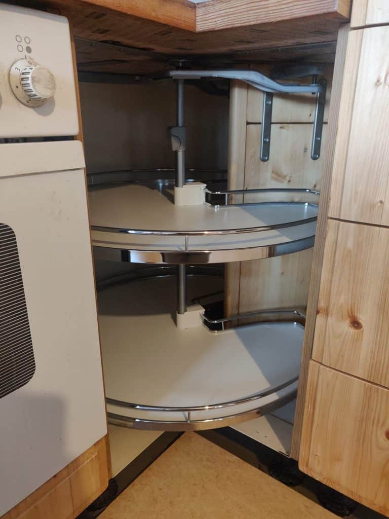 Geöffneter Kücheneckschrank mit ausschwenkbaren Ablageflächen